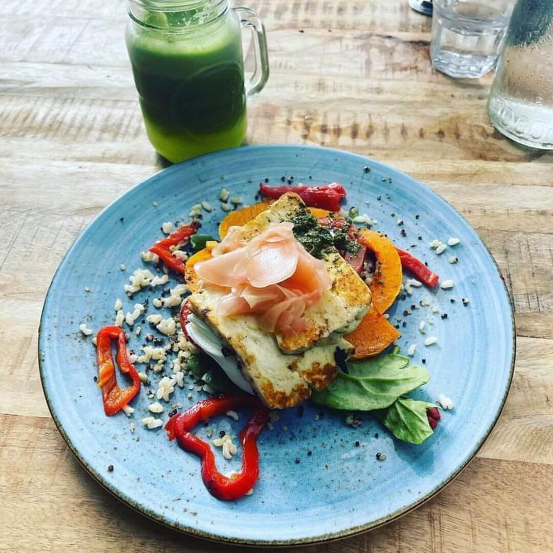 A plate of roasted pumpkin with various vegetables on top.